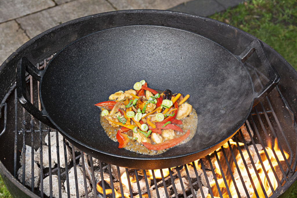 gusseiserner Wok mit Gemüse auf Grill