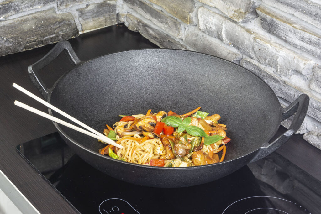 gusseiserner Wok mit Pasta auf Herd