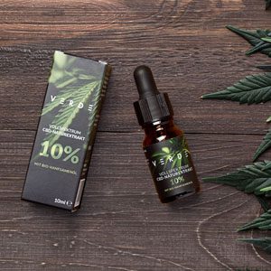 10-cbd-oel CBD Öl mit Hanfblättern auf Holz